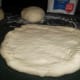 Shape the dough into pizza crusts with your hands working from the inside out.
