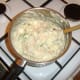 Carefully combining the fish pie filling ingredients