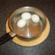 Hard boiled and peeled eggs are cooled in cold water