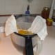 I place cheesecloth over a strainer before I pour the Nasturtium Tisane into a bowl.