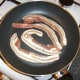 Gently frying bacon slices