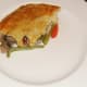 A piece of pastry is laid on top of the rabbit and pork pie filling