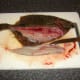 The first fillet is removed from the flounder