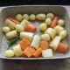 Vegetables and rosemary are mixed with hot duck fat and seasoned