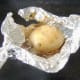 Baked potato is carefully unwrapped from foil