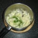 Chopped chives and garlic are stirred in to the mash