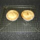 Scotch pies are rested in their casings on a wire rack