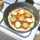 Tomato sauce and vegetable slices are added to pizza omelette