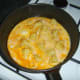 Egg is poured over softened onion and potato