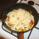 Grated cheese is scattered over the chicken and peppers