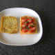 Basil is scattered over strawberries and smoked salmon