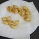 Chicken and pineapple fritters are drained on kitchen paper