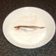 Patting sprats in seasoned flour