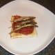 Grilled sprats are laid on spicy tomato sauce