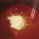 Add sugar, grated Parmesan, and cayenne pepper to vegetable juice to heat while meatballs are formed.