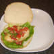 Pineapple salsa is spooned on to chicken burger.