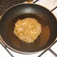 Frying curried chicken burger.
