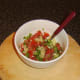 Salsa ingredients are stirred and seasoned.