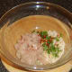 Combining chicken burger ingredients.