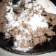 Add 3 to 4 Tablespoons of ALL PURPOSE FLOUR, enough that the flour absorbs the drippings in the pan. Do not use self rising! Stir the flour in with the sausage for 2 to 3 minutes to cook it thoroughly.