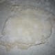 Start to pat the dough down with your fingers and fold it over onto itself 4 or 5 times.