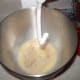 Pour it into a mixer bowl that has the dough hook attachment ready and add the yeast. Wait a few minutes for the yeast to bubble.