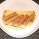 Pork sausages are laid on half naan bread