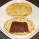 Curried Lorne sausage is laid on naan bread