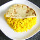 Half naan is laid on rice bed