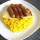 Spiced beef sausages are laid on half naan