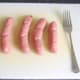 Beef sausages are pricked with a fork