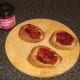 Cranberry sauce is spread on wholemeal toast