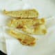 Deep fried plaice fillets are drained on kitchen paper