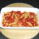 Plaice, pasta and tomato sauce are spooned in to ovenproof dish