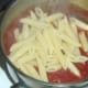Cooked and drained penne pasta is added to tomato sauce