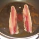 Sardine fillets are pan fried in olive oil