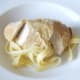Sliced chicken breast is laid on tagliatelle bed