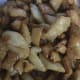 Transfer the fried shakarpara into the hot sugar syrup, making sure that each piece is completely coated.