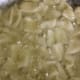 Gently slide the cut dough pieces into the oil for deep-frying.