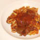 Tagliatelle with tomato and venison sauce is plated