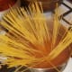 Spaghetti is added to turmeric spiced water