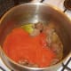 Pureed tomatoes are added to browned venison