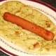 Hot dog is laid on naan bread