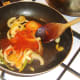 Sweet and sour sauce is added to bell peppers and onion
