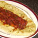 Bhuna sauce is spooned over hot dog on naan bread