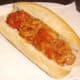 Sweet and sour peppers are spooned on to hot dog