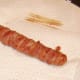 Cocktail sticks or toothpicks are removed from bacon dog
