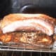Roast pork belly is almost done. Notice how the skin is bubbling up to give a very rough texture.