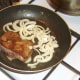 Onions are added to pan with part fried ox liver.