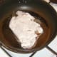 Floured ox liver is added to frying pan.
